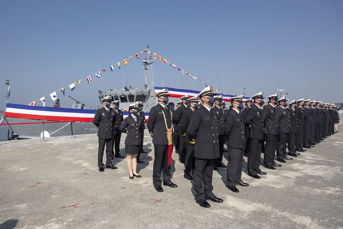 In this photo released by the Taiwan Presidential Office, Taiwanese sailors form up infront of newly commissioned navy minelayers in Kaohsiung city in southern Taiwan on Friday, Jan. 14, 2022. Taiwanese President Tsai Ing-wen presided over a commissioning ceremony for the navy's First and Second Mining Operations Squadrons, which will operate ships able to automatically sow large numbers of small but powerful mines at high speed without the need for divers. (Taiwan Presidential Office via AP)