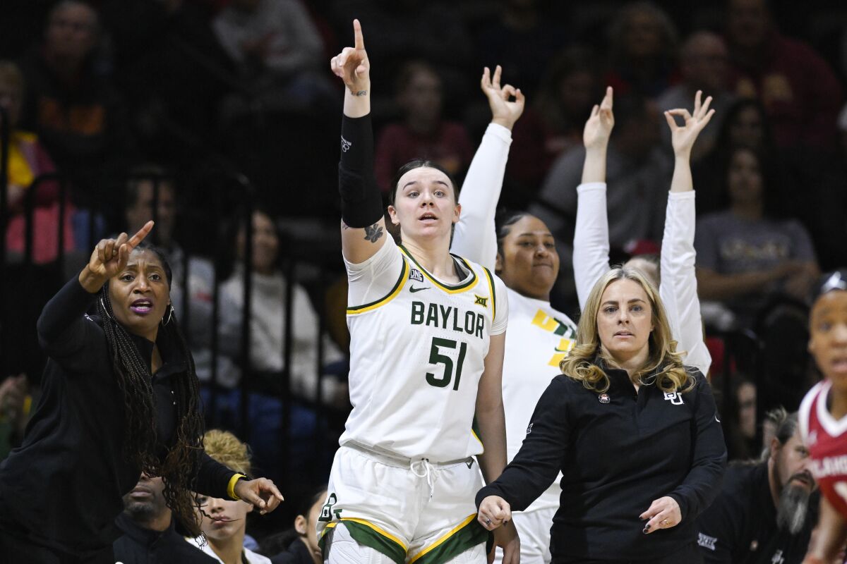 Baylor forward Caitlin Bickle (51) and the rest of the bench celebrates a teammate's 3-point basket as Baylor head coach Nicki Collen, lower right, looks on during the second half of an NCAA college basketball game against Oklahoma in the semifinal round of the Big 12 Conference tournament in Kansas City, Mo., Saturday, March 12, 2022. (AP Photo/Reed Hoffmann)