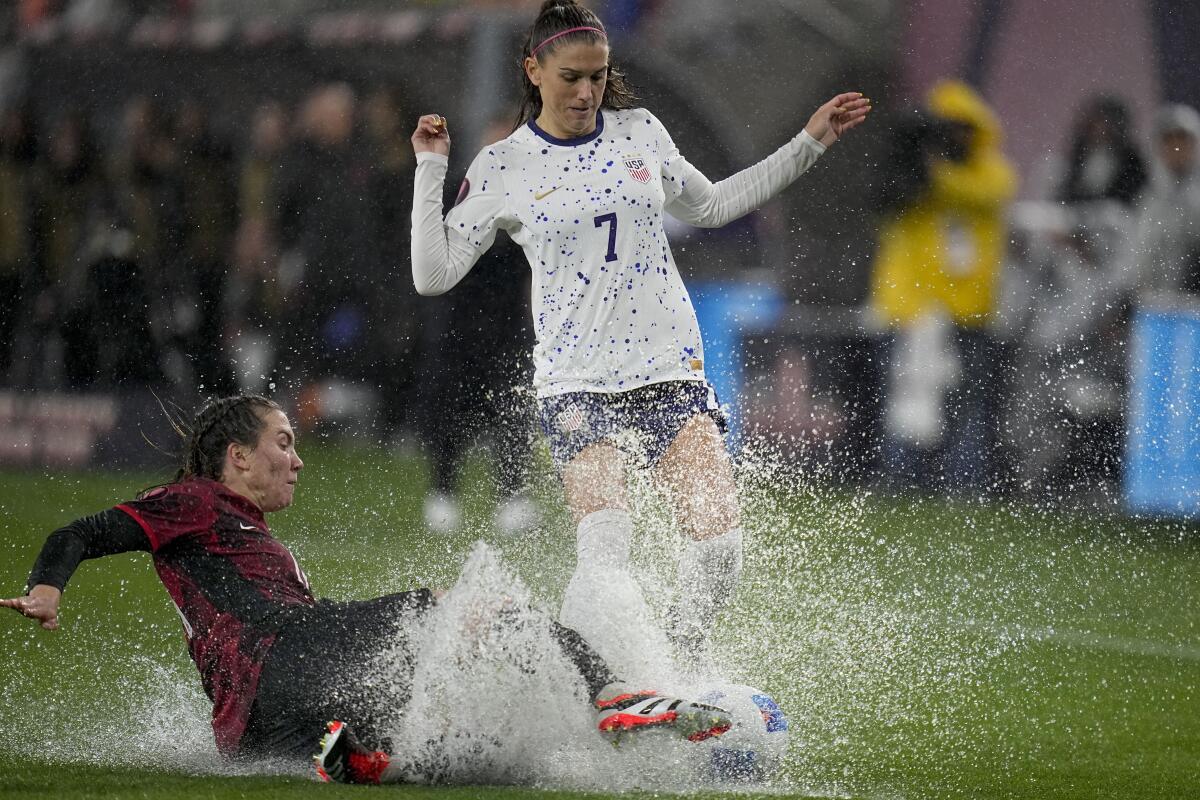 United States' Alex Morgan, above, collides with Canada's 