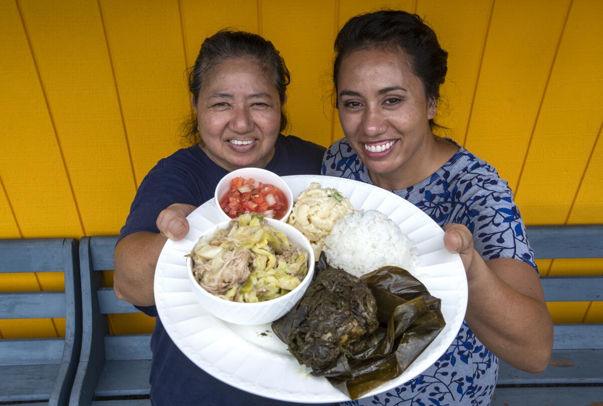 General manager Janice Kaaloa, left, and her daughter, Jaye Kunz, display the Special Plate, which includes chicken lau lau, pork lau lau, lomi salmon and sides, at Kaaloa's Super J's in Captain Cook, Hawaii.