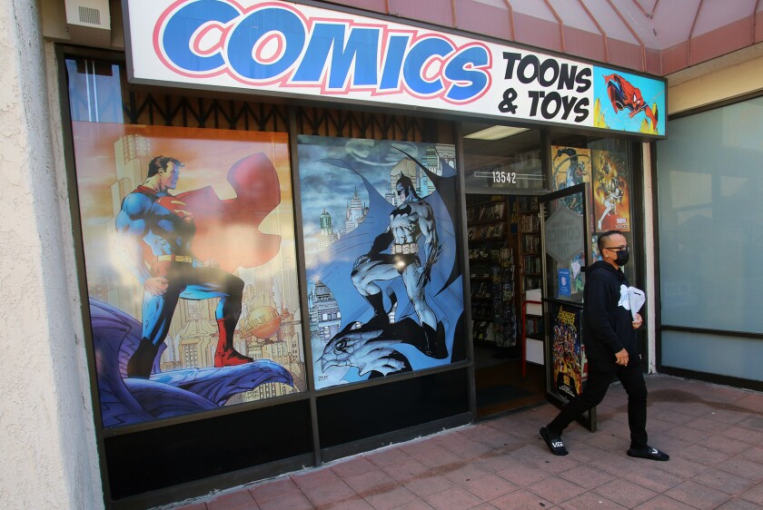 A comic book collector leaves with books at Comics, Toons & Toys in Tustin.