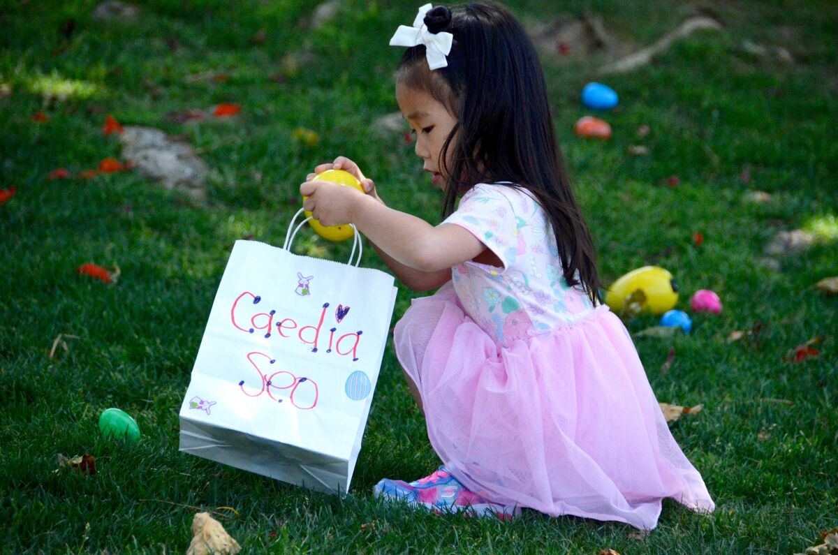 Caedia Seo places a plastic egg in her bag on during the Beyond Blindness Beeper Egg Hunt in 2022.