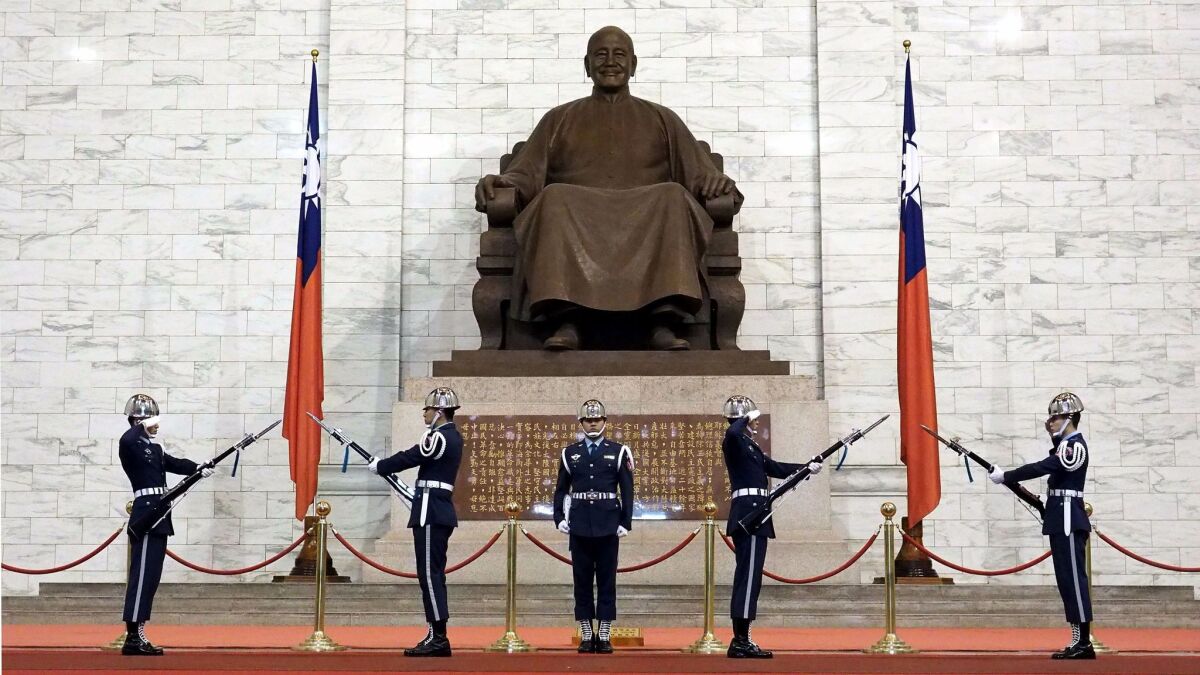 Taiwanese soldiers perform a changing of the guard ceremony before a statues of late President Chiang Kai-shek at the Chiang Kai-shek Memorial Hall in Taipei on Dec. 6, 2017.