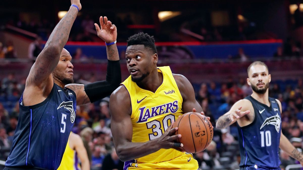 The Lakers' Julius Randle looks for a shot as he gets between the Orlando Magic's Marreese Speights, left, and Evan Fournier during the first half of Wednesday's game.