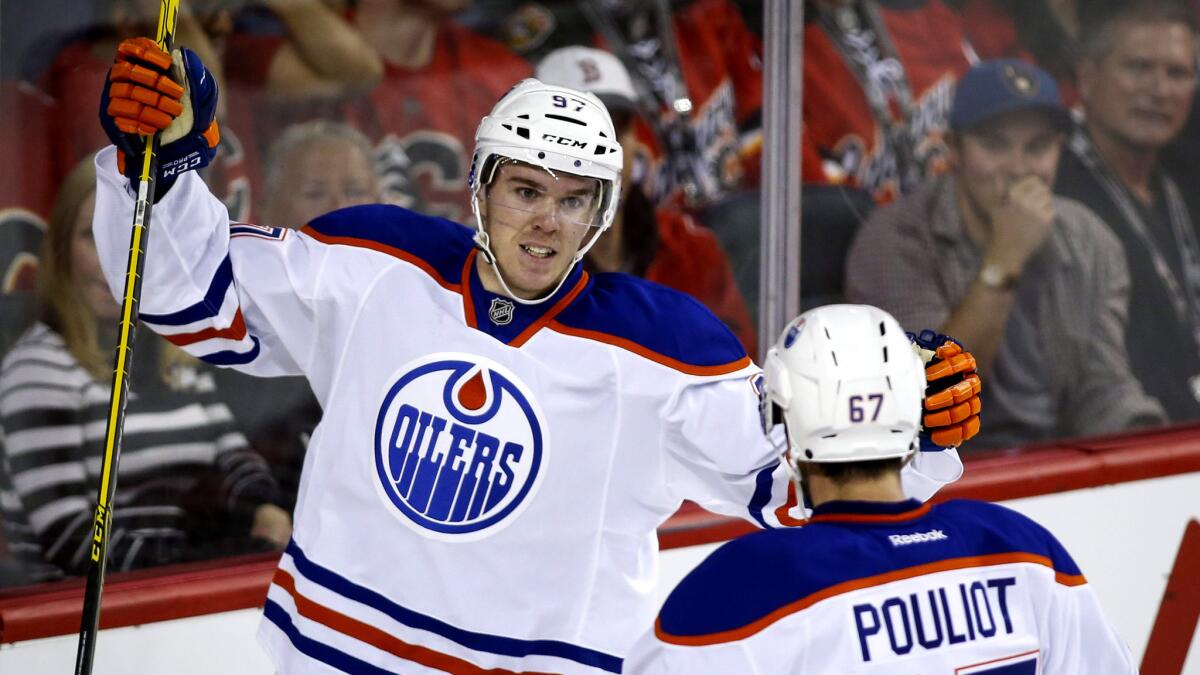 Oilers rookie Connor McDavid celebrates a goal with teammate Benoit Pouliot during a game Oct. 17 in Calgary.