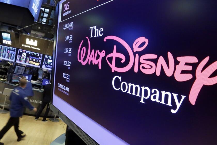 FILE - In this Aug. 8, 2017, file photo, The Walt Disney Co. logo appears on a screen above the floor of the New York Stock Exchange. Disneyâs $71.3 billion acquisition of Twenty-First Century Foxâs entertainment division is one step closer after shareholders approves the deal Friday, July 27, 2018. The tie-up brings together Marvelâs X-Men and Avengers franchises and creates an entertainment behemoth in the digital streaming era. (AP Photo/Richard Drew, File)