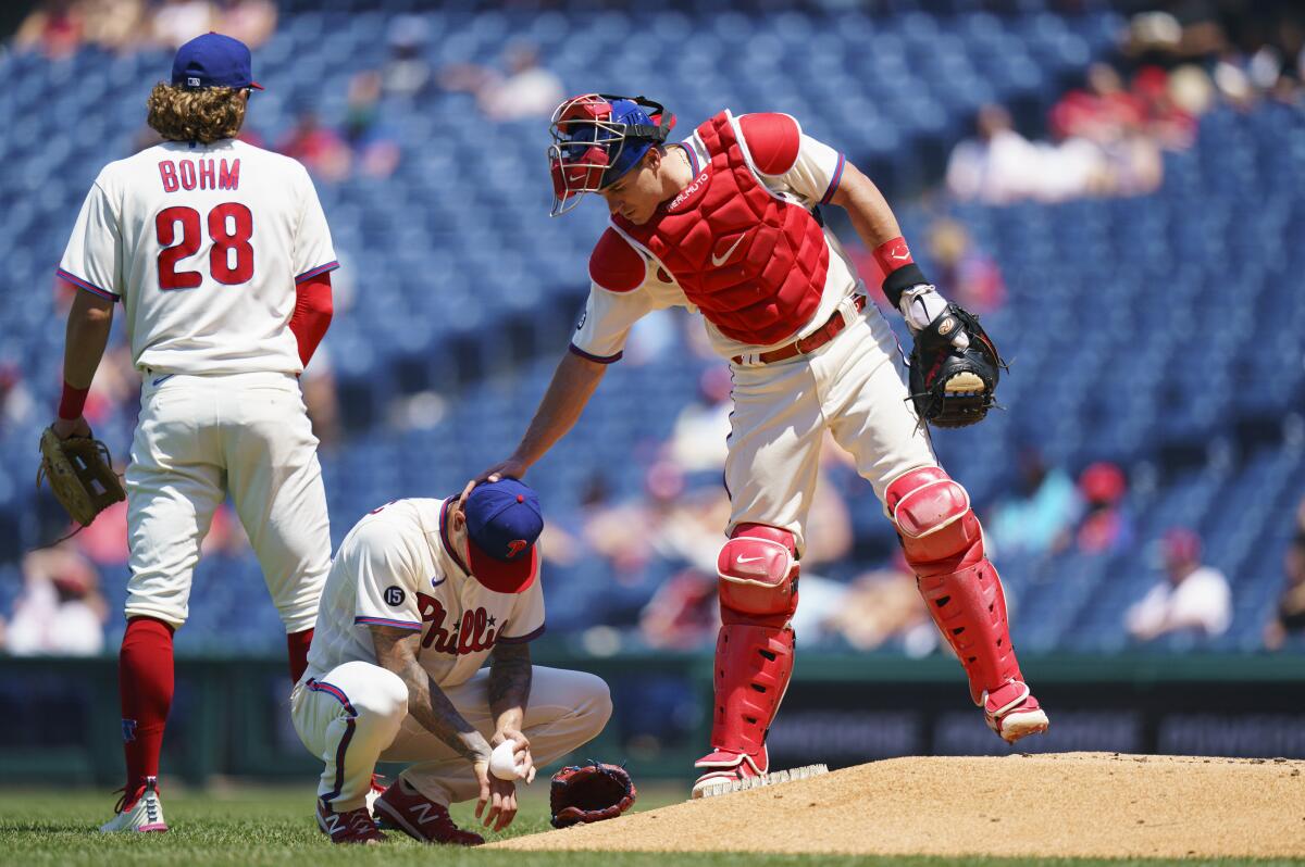 Philadelphia Phillies catcher J.T. Realmuto, right, comes over to talk with starting pitcher Vince Velasquez, center, after Velasquez hit Washington Nationals' Austin Voth in the face with a pitch during the third inning of a baseball game, Sunday, June 6, 2021, in Philadelphia. (AP Photo/Chris Szagola)