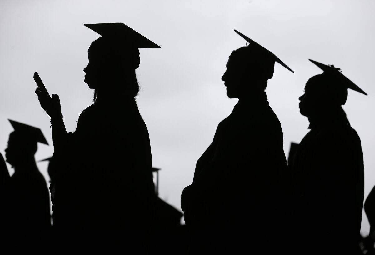  Profiles of graduates in caps and gowns.