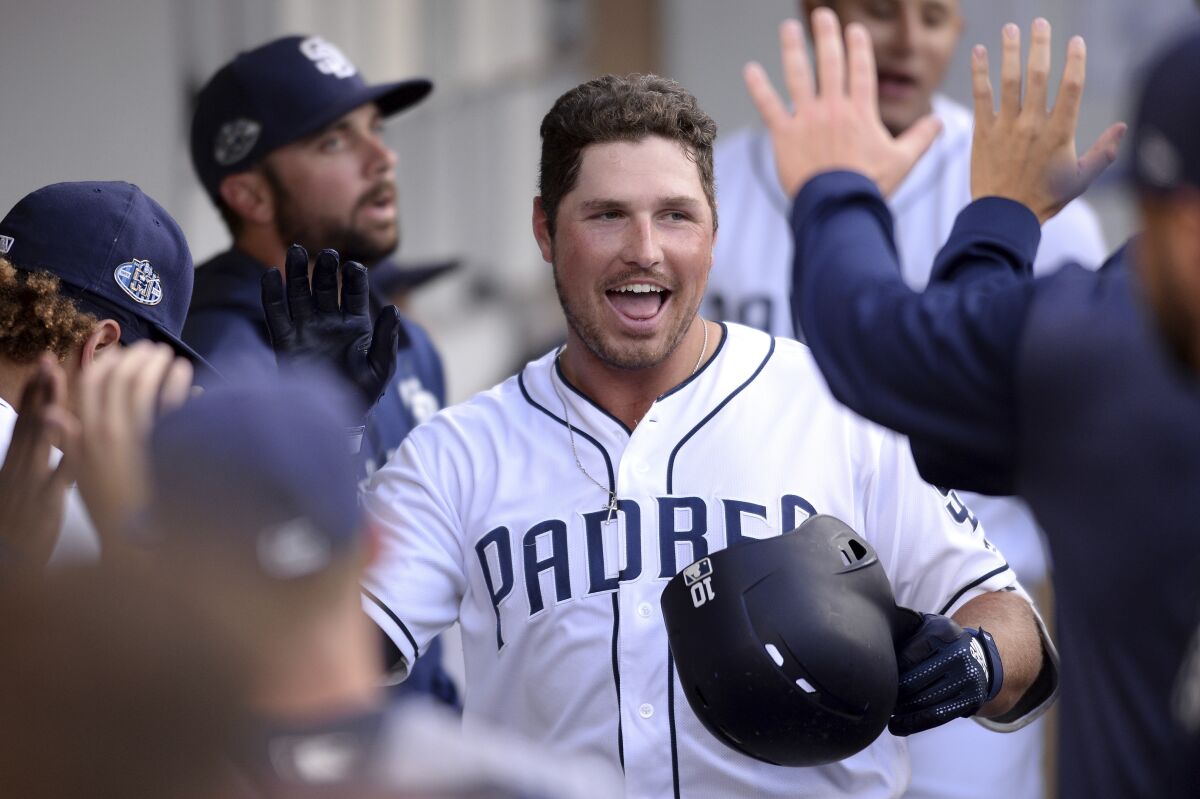 Hunter Renfroe is congratulated in the Padres dugout after hitting his 31st home run of the season on Saturday against the Colorado Rockies.