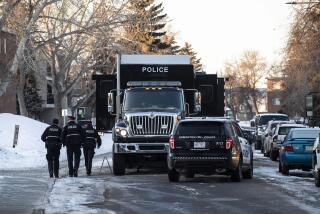Police investigate the scene where two officers were shot and killed on duty in Edmonton on Thursday, March 16, 2023. (Jason Franson /The Canadian Press via AP)