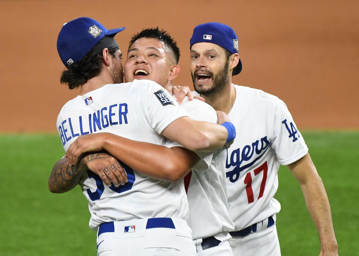 Dodgers pitcher Julio Urias, center, celebrates with Cody Bellinger, left, and Joe Kelly.