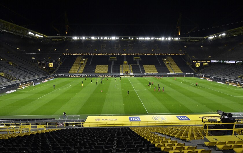 FILE - Players warm up in a stadium without fans prior to the the German Bundesliga soccer match between Borussia Dortmund and Bayern Munich in Dortmund, Germany, Saturday, Nov. 7, 2020. One year late, it is unclear how many fans will be allowed for the Bundesliga clash between Dortmund and Bayern on Saturday, as the BVB has precautionary cancelled all tickets for the match due to the coronavirus pandemic. (AP Photo/Martin Meissner, File)