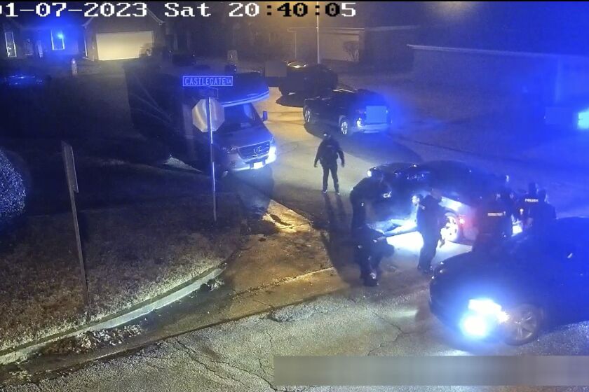 In this image from video released and partially redacted by the city of Memphis, Tenn., on Jan. 27, 2023, Tyre Nichols leans against a car after a brutal attack by five Memphis Police officers on Jan. 7, in Memphis. Officer Demetrius Haley, who is standing bent over in front of Nichols, is seen taking photographs of Nichols, which he sent to other officers and a female acquaintance. The new revelation about Haley's actions were released Tuesday, Feb. 7, in documents that provide a scathing account of what authorities called the “blatantly unprofessional” conduct of the officers involved in the fatal beating of Nichols. (City of Memphis via AP)