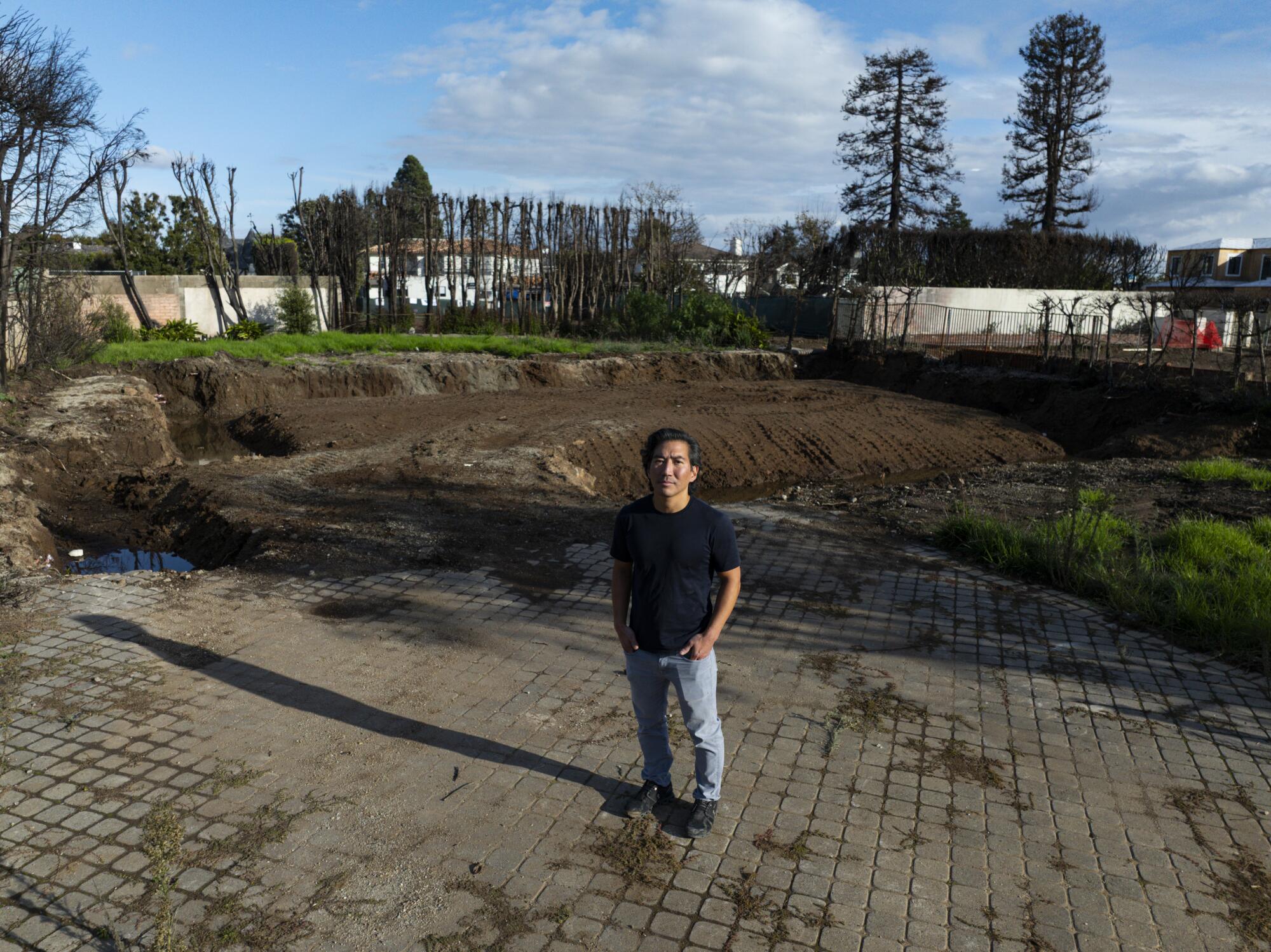 Ricardo Kawamura stands next to the location of the home he was staying in that was burned down during the Palisades fire.