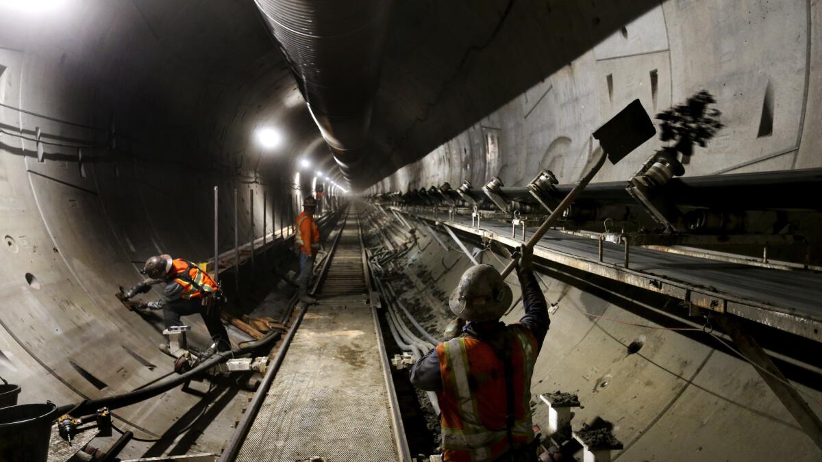 The muck, a combination of earth and chemicals and water, is whisked along the conveyor belt. If it falls of the conveyor, miners must shovel it back at the tail end of the tunnel boring machine located deep underneath the streets of downtown Los Angeles. (Mel Melcon / Los Angeles Times)