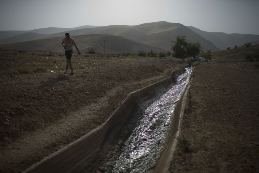 A Palestinian man, walking by an aqueduct built by Herodes, near the Palestinian village of Auja in the West Bank, April 27, 2015.
