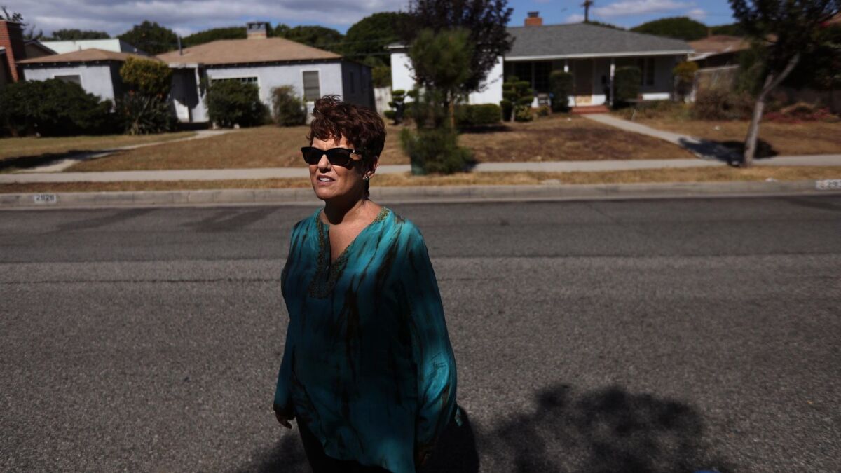 Karen Pomer, 63, a local political activist, stands across the street from a Santa Monica home where she sought help 23 years ago after being abducted and raped at gunpoint.