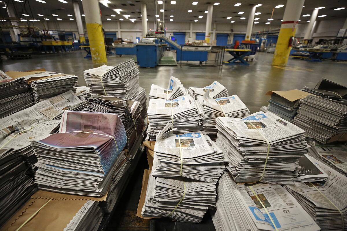 Stacks of newspapers sit ready for distribution at The Times' printing facility south of downtown Los Angeles in 2019. 