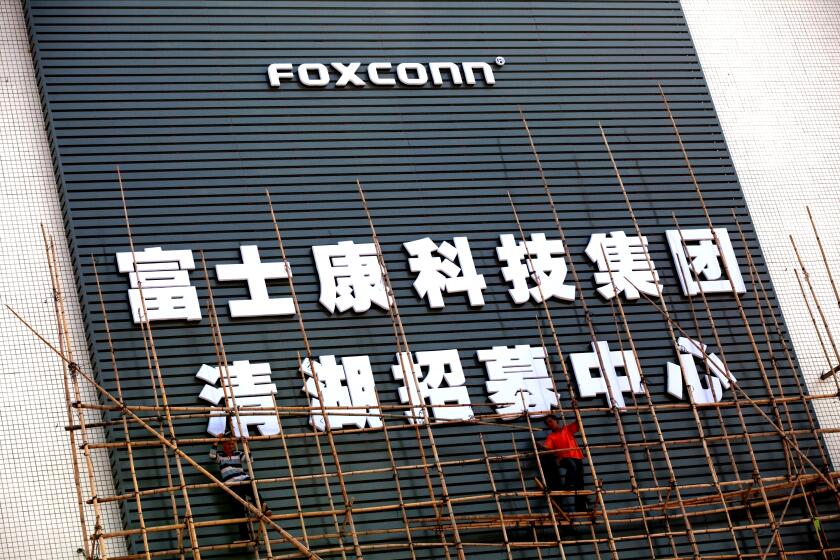 SHENZHEN, CHINA - NOVEMBER 28: Workers put up scaffolding on a building owned by the contract manufacturer Foxconn International Holdings Ltd on November 28, 2010 in Shenzhen, China. According to the US Commercial Service, Shenzhen is one of the fastest growing cities in the world. Home of the Shenzhen Stock Exchange and the headquarters of numerous technology companies, the now bustling former fishing village is considered southern China's major financial centre. (Photo by Daniel Berehulak/Getty Images)