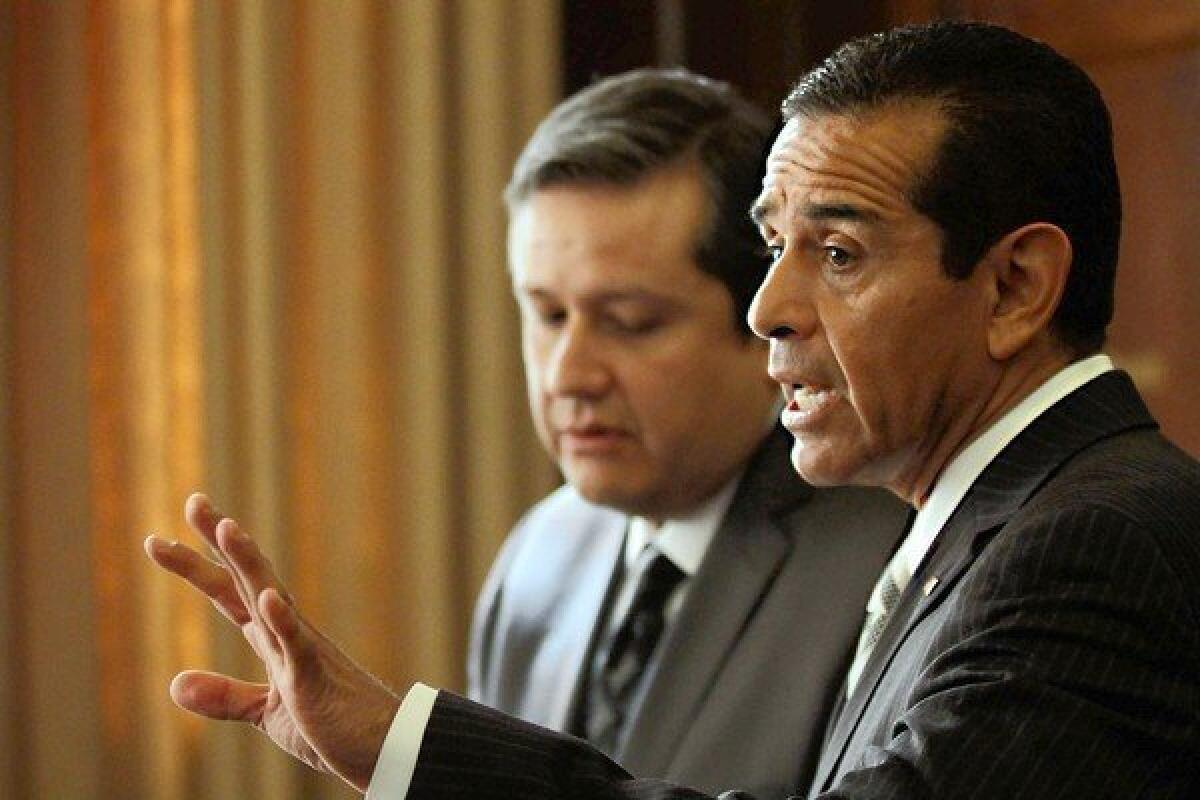 City Administrative Officer Miguel Santana, left, listens as Mayor Antonio Villaraigosa responds to a question about the AEG sale during a news conference at Los Angeles City Hall.