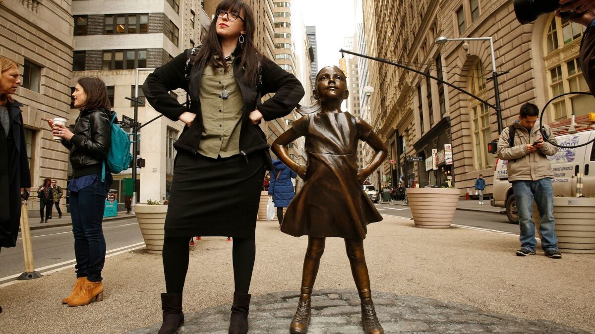 New York: Layah Shagalow beside a new bronze statue, "Fearless Girl," that stands near Wall Street's famed "Charging Bull" on International Women's Day.