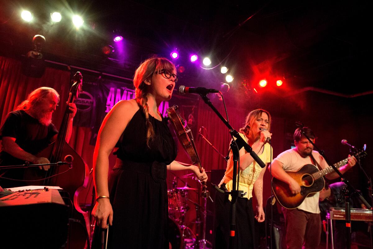 Four musicians perform onstage