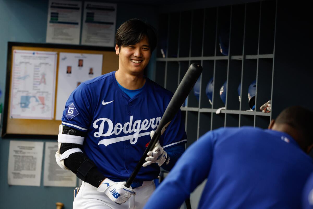 Dodgers star Shohei Ohtani smiles in the dugout before a game between the Dodgers and Angels.