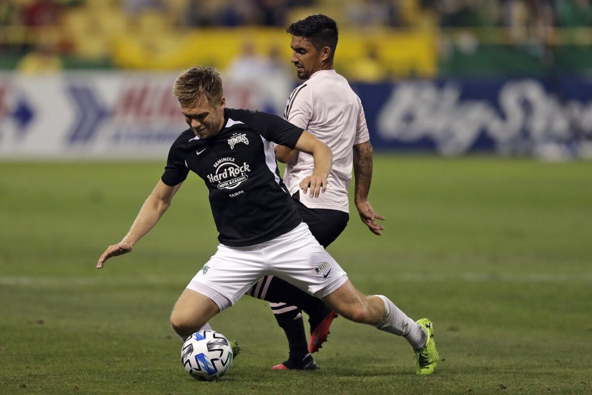 Inter Miami FC's A.J. DeLaGarza, back, takes down Tampa Bay Rowdies' Zach Steinberger in a friendly in February.