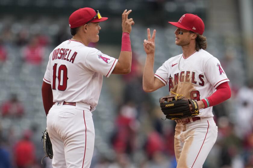 Los Angeles Angels' Gio Urshela (10) and Brett Phillips (8) celebrate the team's 3-2 win over the Washington Nationals in a baseball game Wednesday, April 12, 2023, in Anaheim, Calif. (AP Photo/Marcio Jose Sanchez)