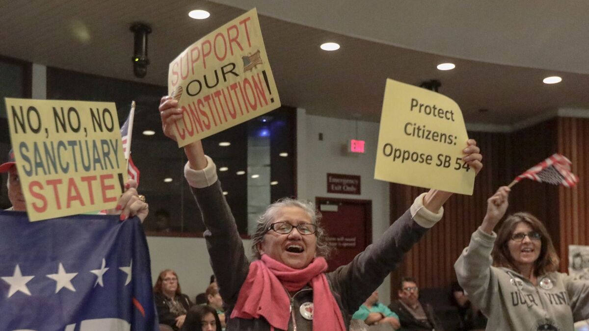 People celebrate the Orange County Board of Supervisors’ resolution Tuesday to condemn California’s “sanctuary” laws protecting undocumented immigrants.