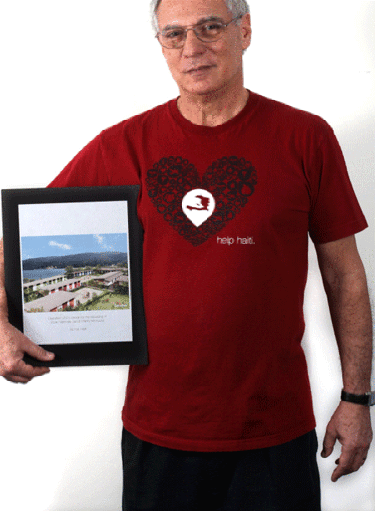 Richard Walden, founder of the disaster relief group Operation USA is seen in his his office with a poster of the school his org built in Jacmel, Haiti.