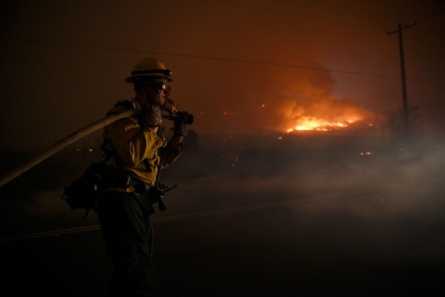 Firefighters make a defensive move on the front lines of the Sherpa Fire to avoid it from moving onto the 101 freeway, along Calle Real road, in Goleta, Calif.