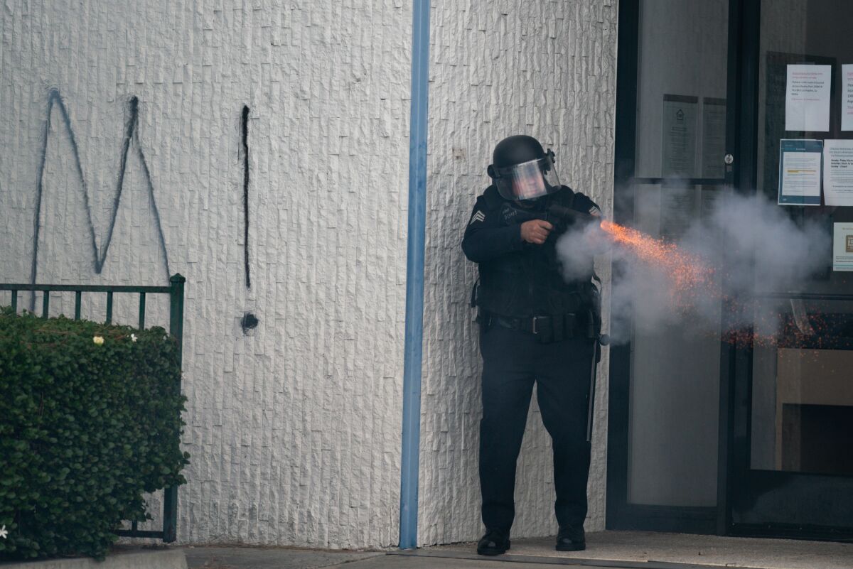 A law enforcement officer discharges a weapon in the Fairfax District on May 30.