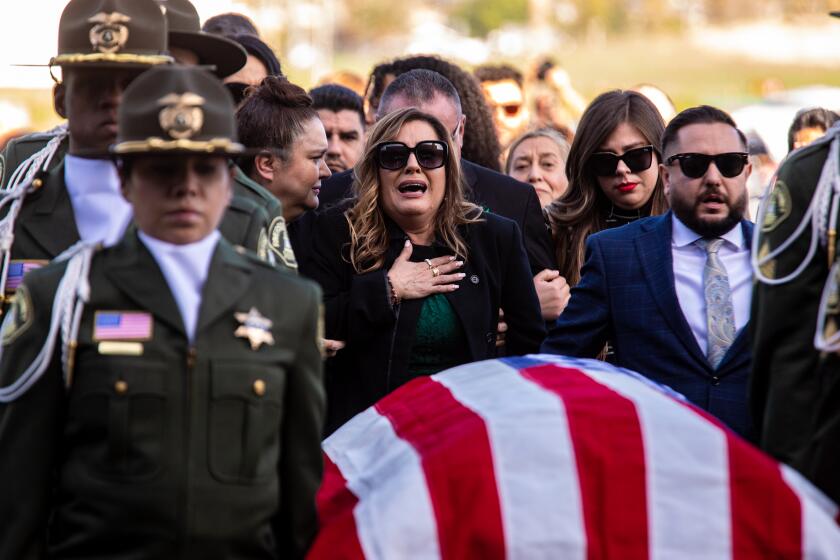 Riverside, CA - January 06: Grieving mother Rebecca Cordero and other family members follow as Riverside County Sheriff pallbearers escort casket carrying Riverside county deputy Isaiah Cordero, killed last month during a traffic stop, at a funeral service at Harvest Christian Fellowship Church on Friday, Jan. 6, 2023 in Riverside, CA. (Irfan Khan / Los Angeles Times)