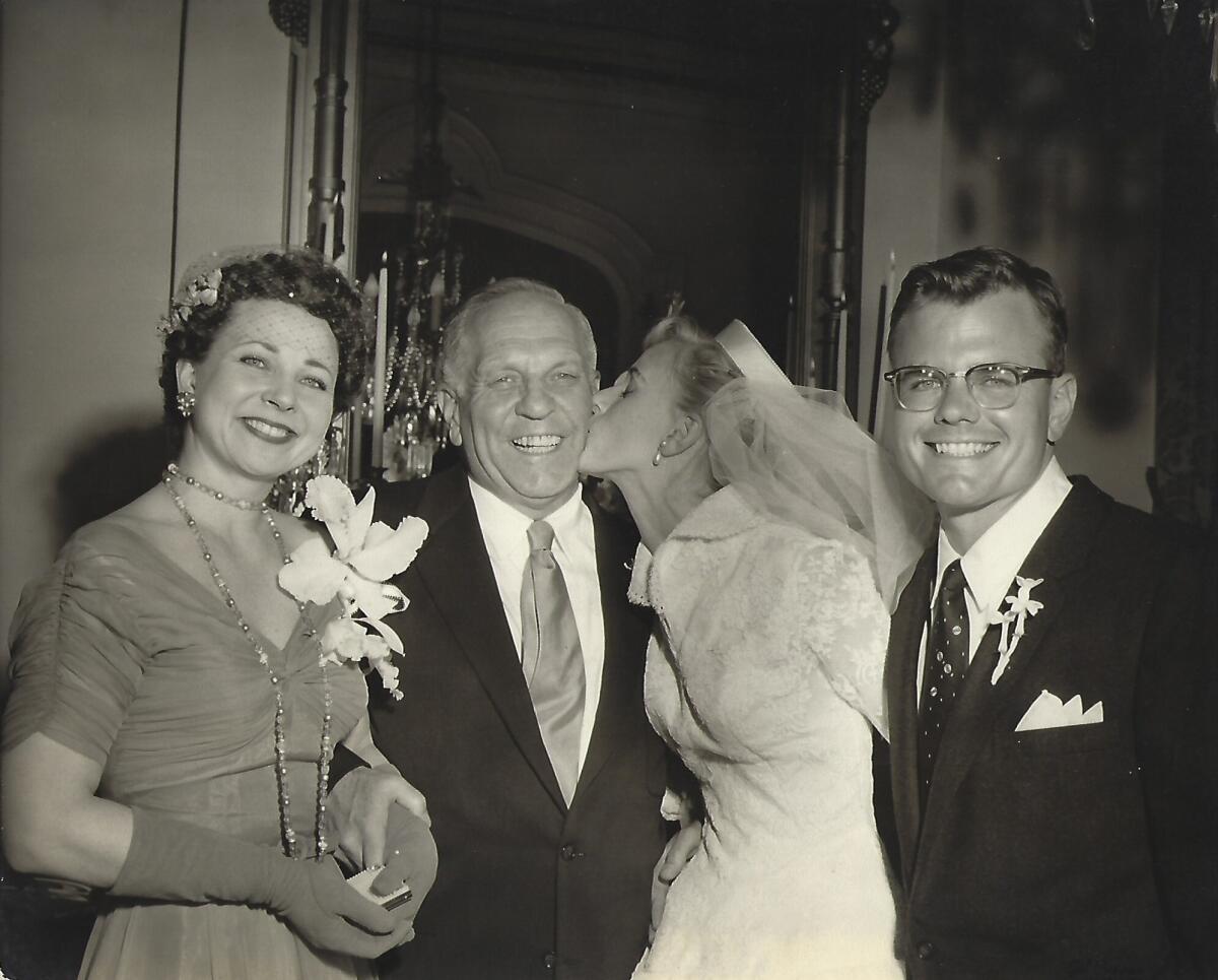 A bride kisses her father on the cheek