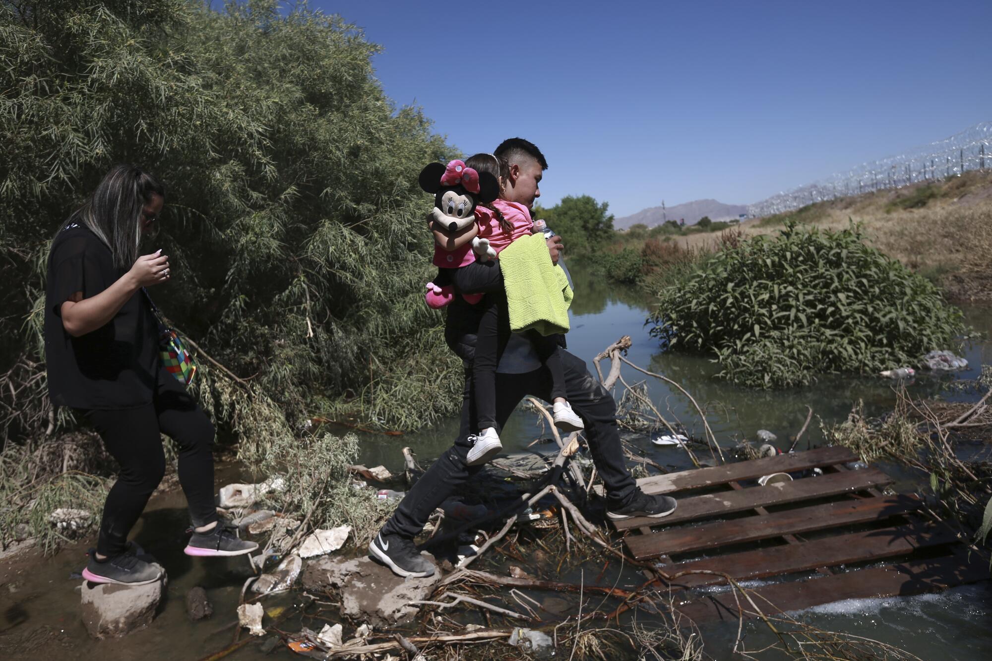 Migrants cross the Rio Grande river into the United States from Ciudad Juarez, Mexico.