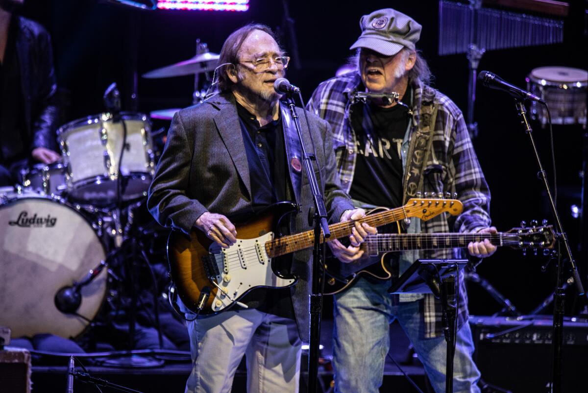 Stephen Stills and Neil Young with guitars onstage