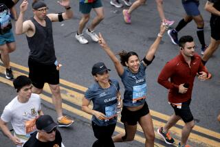 SAN DIEGO, CA - JUNE 04, 2023: A woman waves as she and fellow runners head north on Sixth Avenue during the Rock 'n' Roll San Diego Marathon on Sixth Avenue in San Diego on Sunday, June 4, 2023. (Hayne Palmour IV / For The San Diego Union-Tribune)