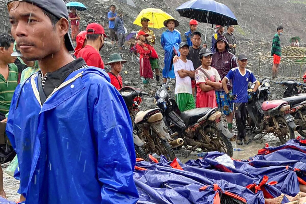 People gather near the bodies of victims of a landslide in northern Myanmar.