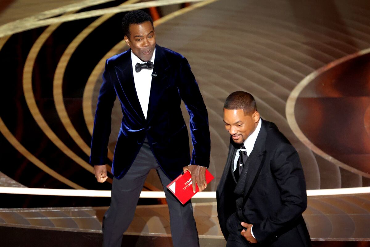 Will Smith leaves the Oscars stage after slapping Chris Rock.