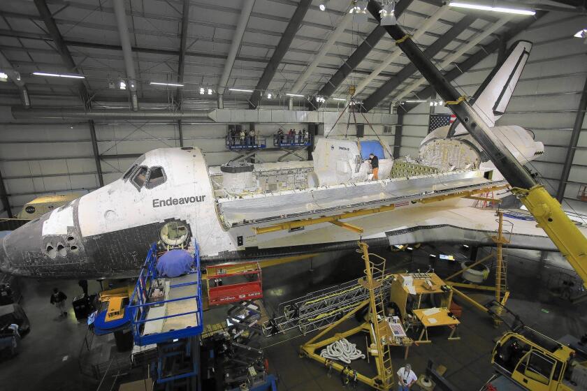 The payload bay doors of the space shuttle Endeavour, housed at the California Science Center, stand open for the installation of equipment.