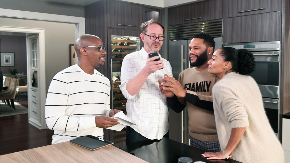 "Black-ish's" new co-showrunners Kenny Smith, left, and Jonathan Groff talk with costars Anthony Anderson and Tracee Ellis Ross at the studios in Burbank.