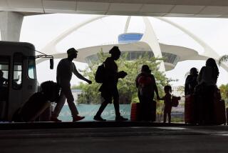 Los Angeles, CA - August 29: Travelers are silhouetted by The Theme Building as they arrive and find transportation while kicking off the getaway Labor Day weekend travel at LAX in Los Angeles Thursday, Aug. 29, 2024. (Allen J. Schaben / Los Angeles Times)