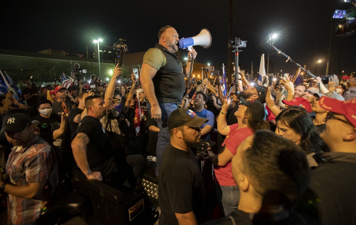 Far-right radio host and conspiracy theorist Alex Jones rallies Trump supporters protesting as ballots are counted in Phoenix