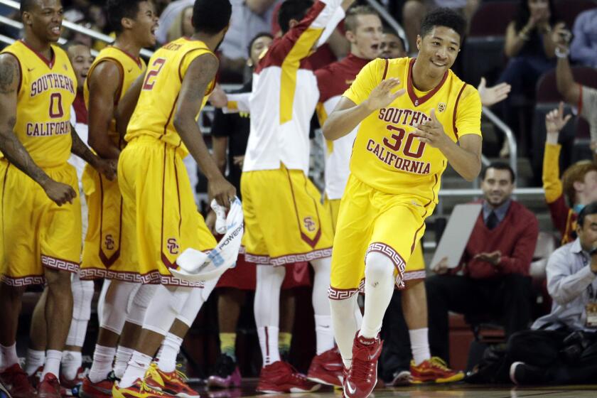 USC forward Elijah Steward (30) as well as teammates on the bench celebrate after a basket in the second half of a 68-55 victory over Oregon State on Saturday at the Galen Center.