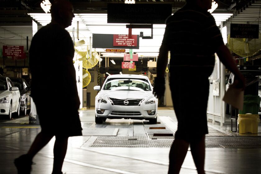 FILE - Workers at the Nissan plant in Smyrna, Tenn., walk by a Nissan Altima sedan on May 15, 2012. Fewer than 100 employees out of the thousands who work at Nissan's auto assembly plant in Tennessee can hold a vote on whether to form a small union, according to a ruling Thursday, Feb. 2, 2023, by the federal labor board. (AP Photo/Erik Schelzig, File)