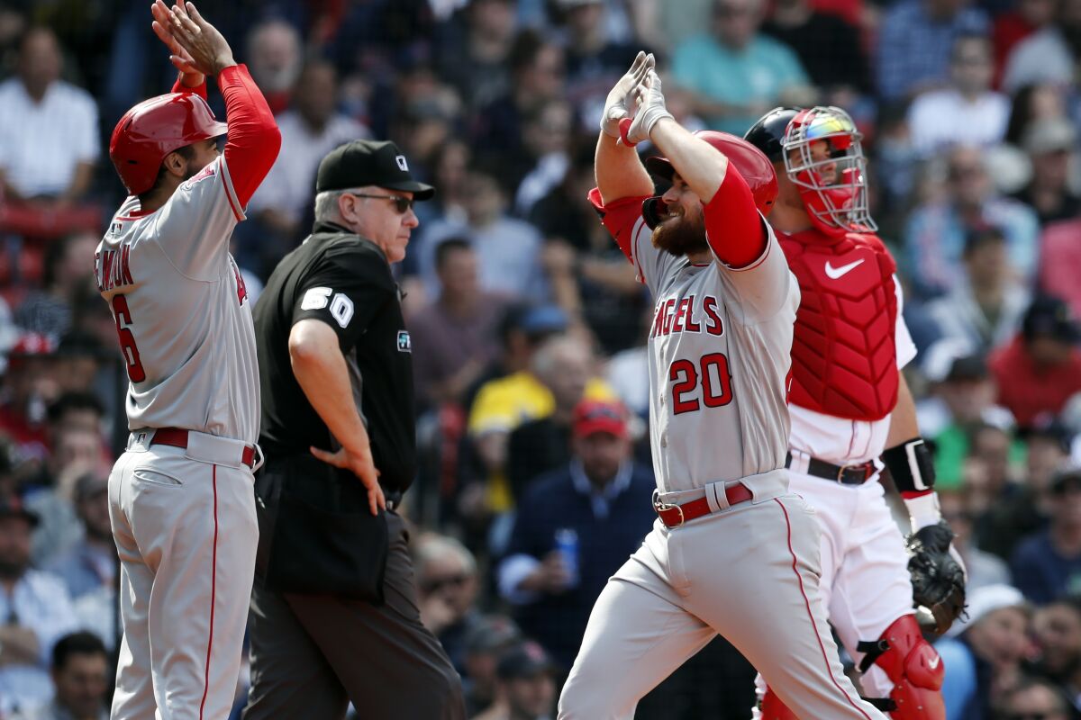 Jared Walsh celebrates with Angels teammate Anthony Rendon after hitting a two-run home run.
