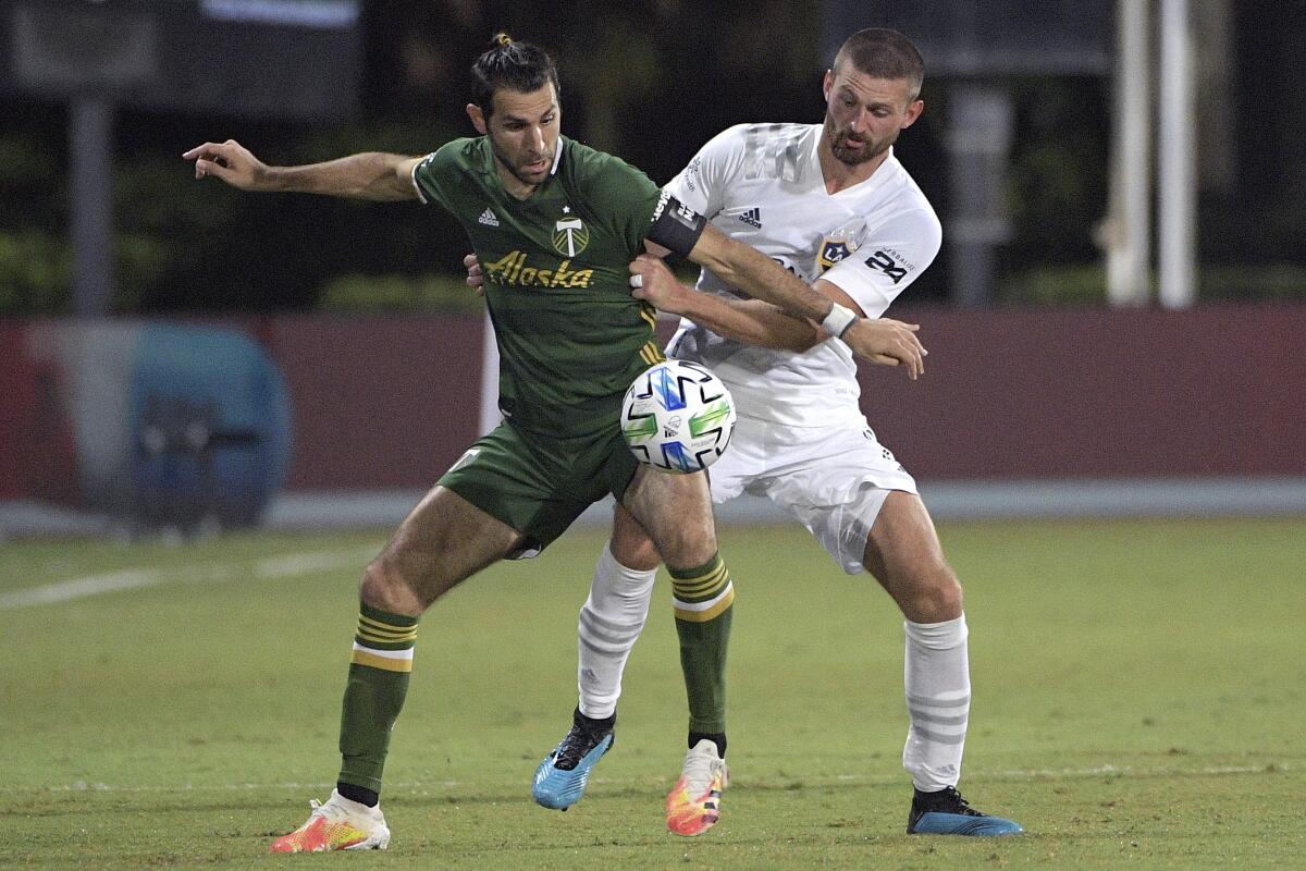 Portland Timbers midfielder Diego Valeri, left, and LA Galaxy defender Perry Kitchen in an MLS game Monday