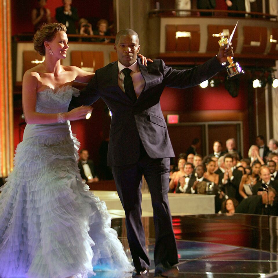 Jamie Foxx, who won lead actor for "Ray," is congratulated by Charlize Theron onstage at the 77th Academy Awards.