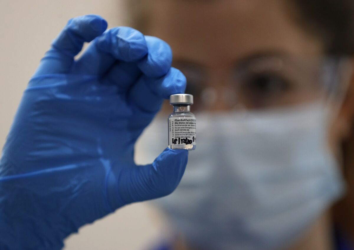 A nurse holds a vial of the Pfizer-BioNTech COVID-19 vaccine.
